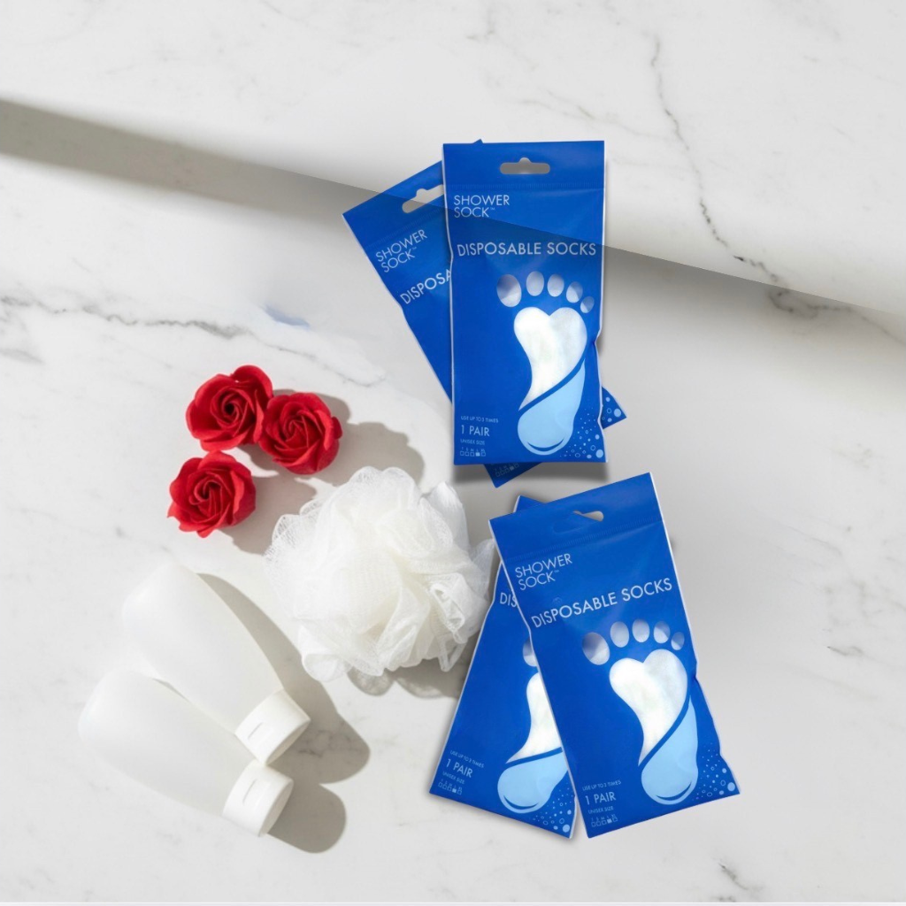 Floor lay of shower socks, loofah and red roses